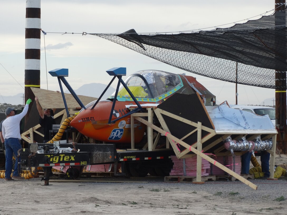 A unique “hot box” was fabricated to satisfy the specific temperature requirements for this F-35 canopy test conducted by the 846th Test Squadron, 704th Test Group, Arnold Engineering Development Complex, March 27, 2020, at Holloman Air Force Base, N.M. The individuals in the picture are securing the “hot box” structure in preparation for the final closure prior to the canopy test. (U.S. Air Force photo by Timothy Gros)