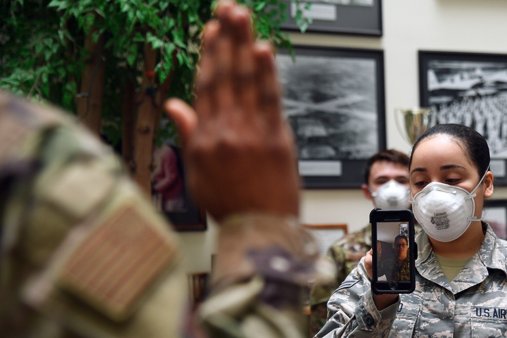 Maj. Yaira Nevarez, left, 66th Force Support Squadron deputy director, administers the oath of enlistment to Staff Sgt. Jennifer Rogers during a virtual reenlistment at Hanscom Air Force Base, Mass., April 28, while Airman 1st Class Jazlynn Liranzo, 66 FSS Career Development technician, holds the phone and Senior Airman Dominik Daigneault, 66 FSS Force Management journeyman, looks on. Rogers, whose background is as a cryptologic language analyst, is returning to active duty following participation in the Career Intermission Program. (U.S. Air Force photo by Linda LaBonte Britt)