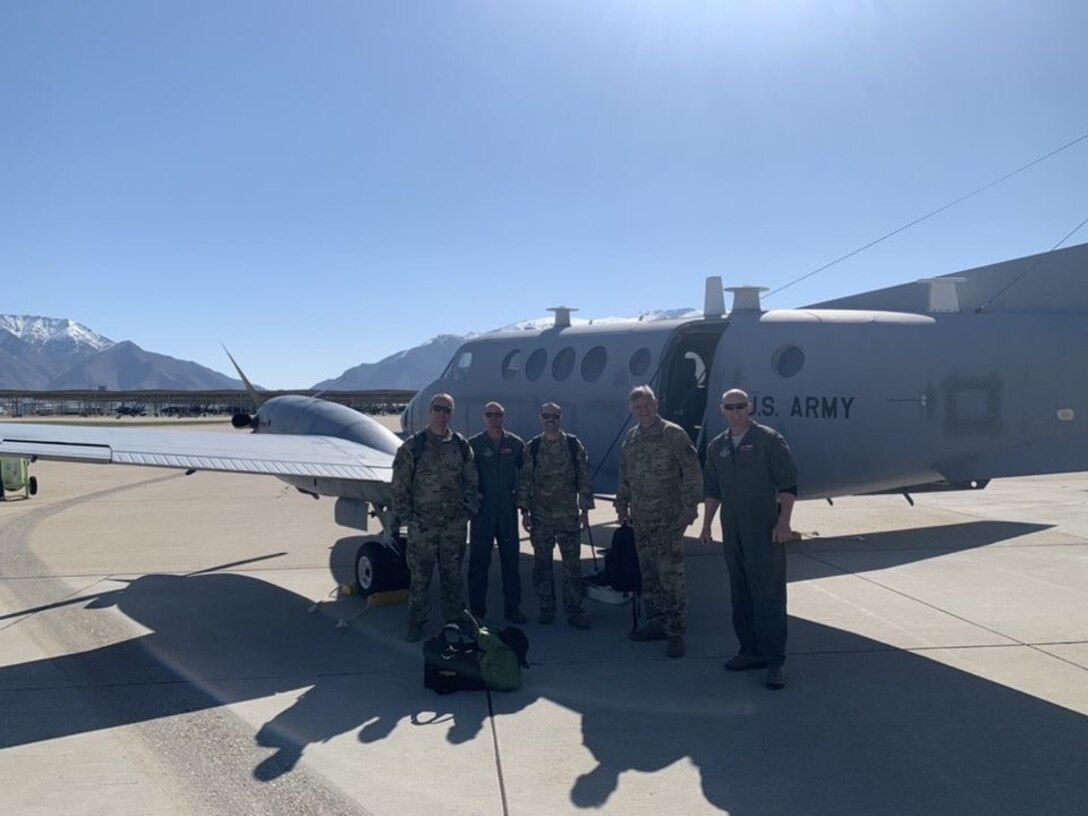 Aircrew pose for a group photo in front of a C-12 aircraft.