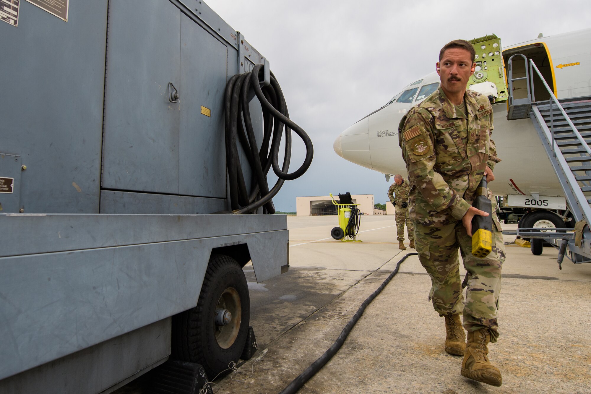 Photos shows a man in uniform going to plug in a large power cable.