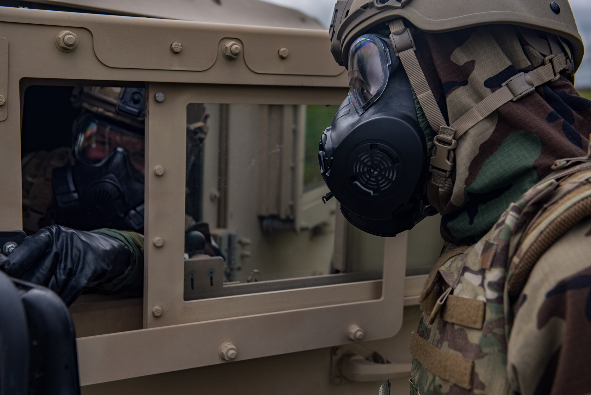 Staff Sgt. Stephen Dobbins, left, and Senior Airman Dawson Hindman, both 509th Civil Engineer Squadron Explosive Ordinance Disposal technicians, talk to each other during chemical ordinance disposal training at Whiteman Air Force Base, Missouri, April 30, 2020.