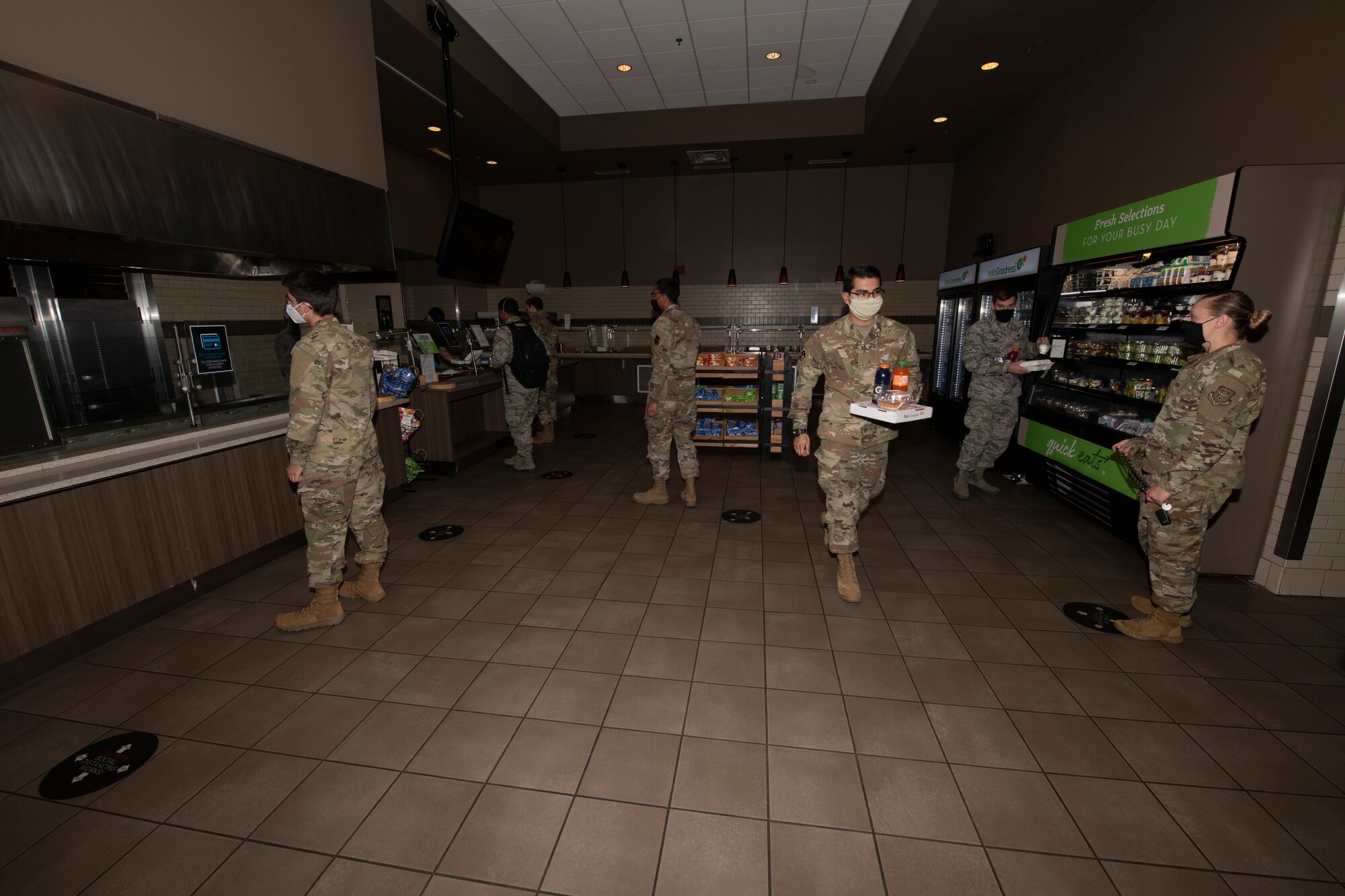 U.S. Airmen maintain physical distancing during the lunch service inside the Monarch Dining Facility April 24, 2020, at Travis Air Force Base, California. The Monarch is offering to-go meals to service members only due to the coronavirus pandemic. While inside the Monarch, all patrons must maintain at least six feet of separation from one another. (U.S. Air Force photo by Tech. Sgt. James Hodgman)
