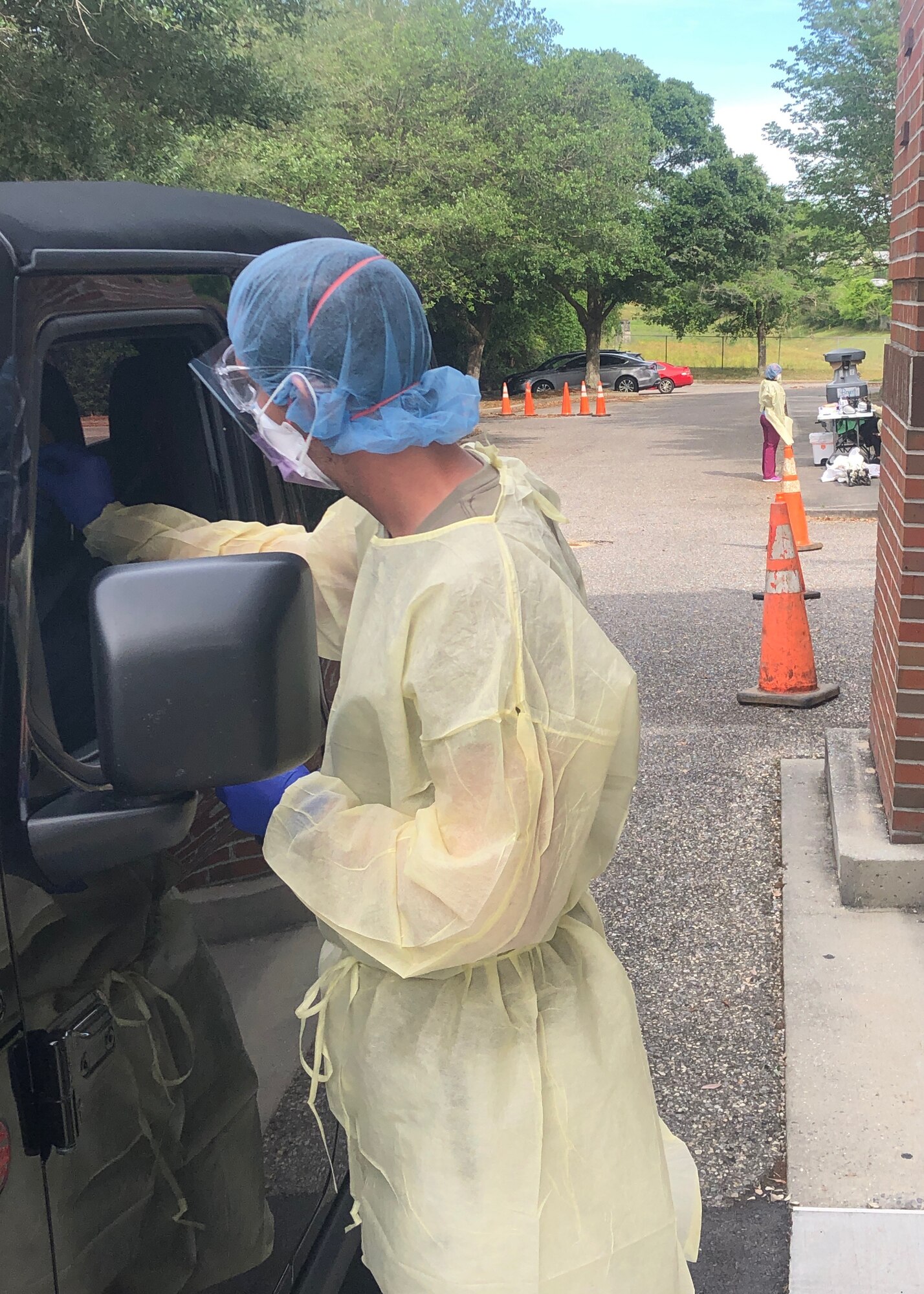 Hardy Watts, medical assistant at Ascension Sacred Heart Pensacola, Florida, conducts a COVID-19 test on a patient in the testing line at the hospital. Watts is a senior airman on a fire team in the 403rd Security Forces Squadron of the 403rd Wing. (courtesy photo)