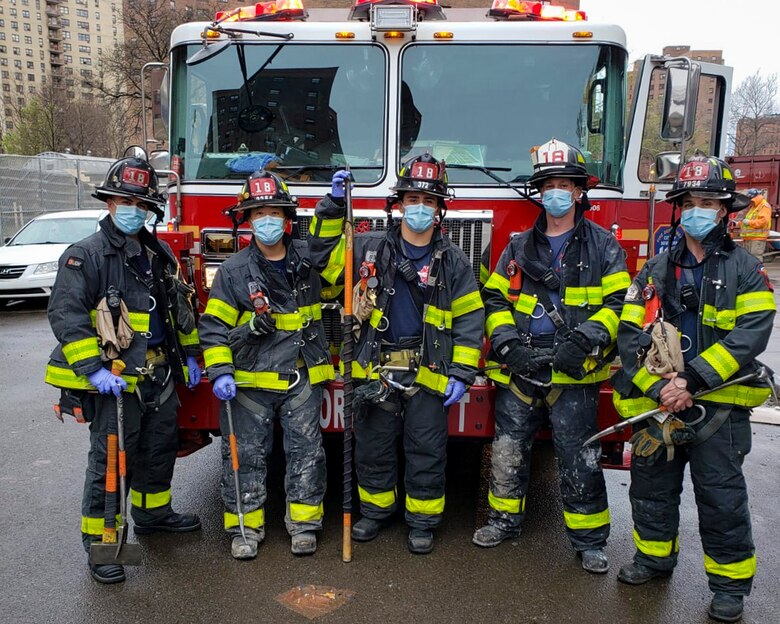 Senior Airman Ruben Rios, 514th Air Mobility Wing photojournalist, Joint Base McGuire-Dix-Lakehurst, N.J., poses for a photo with members from Ladder 18, April 9, 2020. Rios works as a firefighter at Tower Ladder 18 of the New York City Fire Department in the Lower East Side, N.Y.