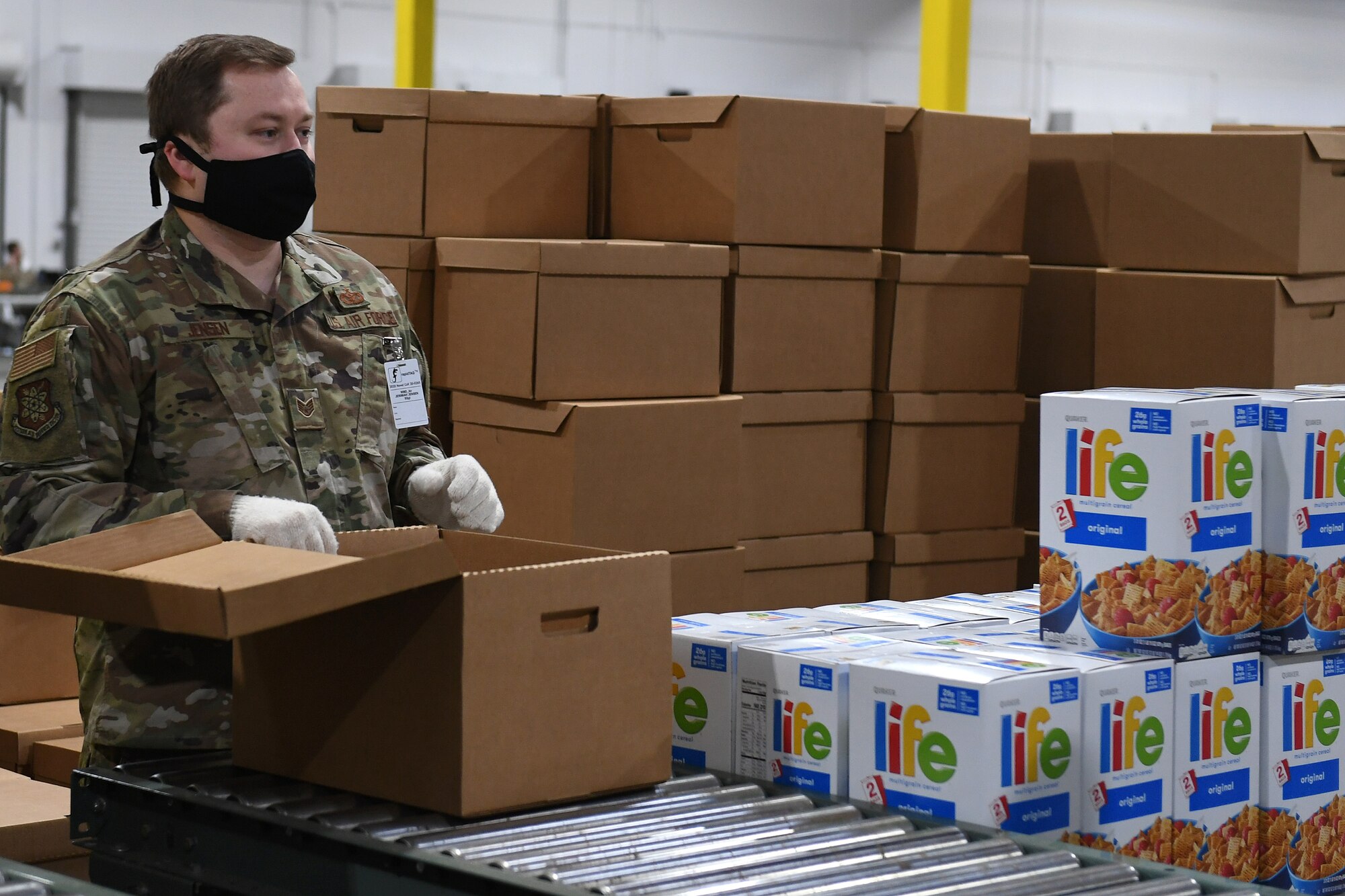 U.S. Air Force Staff Sgt. Jeremiah Jensen, assigned to the 225th Air Defense Squadron, prepares food boxes at the Food Lifeline COVID Response warehouse April 23, 2020 in Seattle, Washington.  More than 250 Air and National Guardsmen are assigned to the warehouse where they are able to prepare, on average, 268 boxes an hour per line. (U.S. Air National Guard photo by Master Sgt. Tim Chacon)