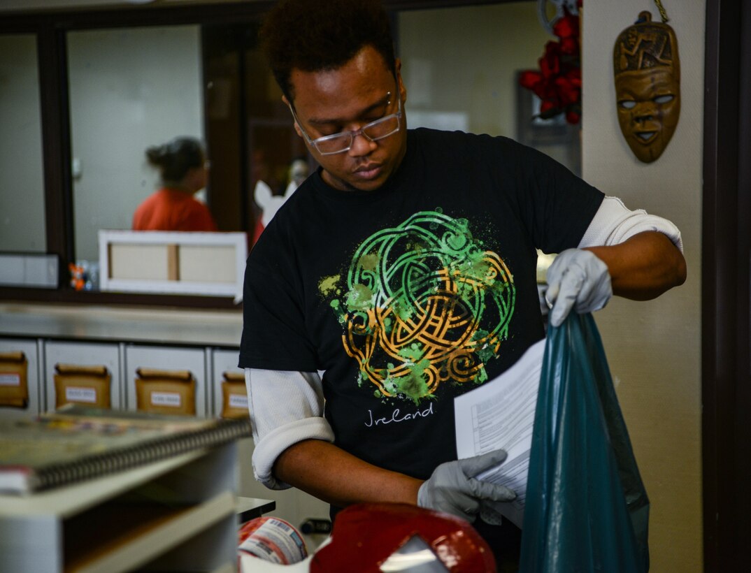 Michael Tablate, School Age Program youth program assistant, places old papers in a trash bag in the School Age Center at Ramstein Air Base, Germany, March 18, 2020.