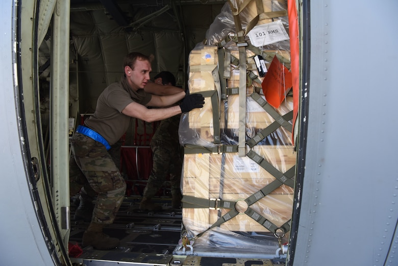 U.S. Air Force Staff Sgt. Ryan Hoback, 721st Aerial Port Squadron ramp supervisor, pushes cargo during a C-130J Super Hercules aircraft.