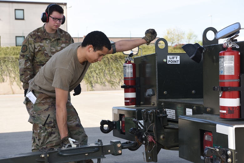 U.S. Air Force Tech Sgt. William Rodriguez-Febres 721st Aerial Port Squadron ramp services noncommissioned officer, connects an engine trailer tow bar.