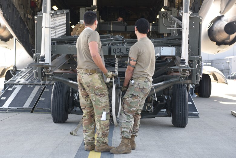 Airmen from the 721st APS and the 816th EAS unload trailers and a C-17 aircraft engine, showcasing their ability to rapidly ensure the aircraft is available for immediate airlift operations. (