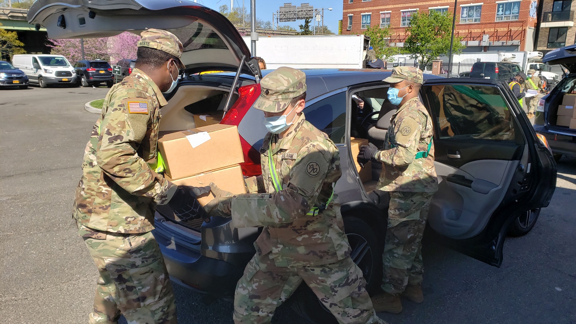 New York Army National Guard Soldiers, from left, Spc. Davier Weste, Spc. Cody Roche and Staff Sgt. Andre Hayden, assigned to the 1st Battalion, 258th Field Artillery, part of the 27th Infantry Brigade Combat Team, load cars with meals at the Queens Food Distribution Site May 2, 2020. The meals will be delivered to people who are quarantined and unable to go shopping.