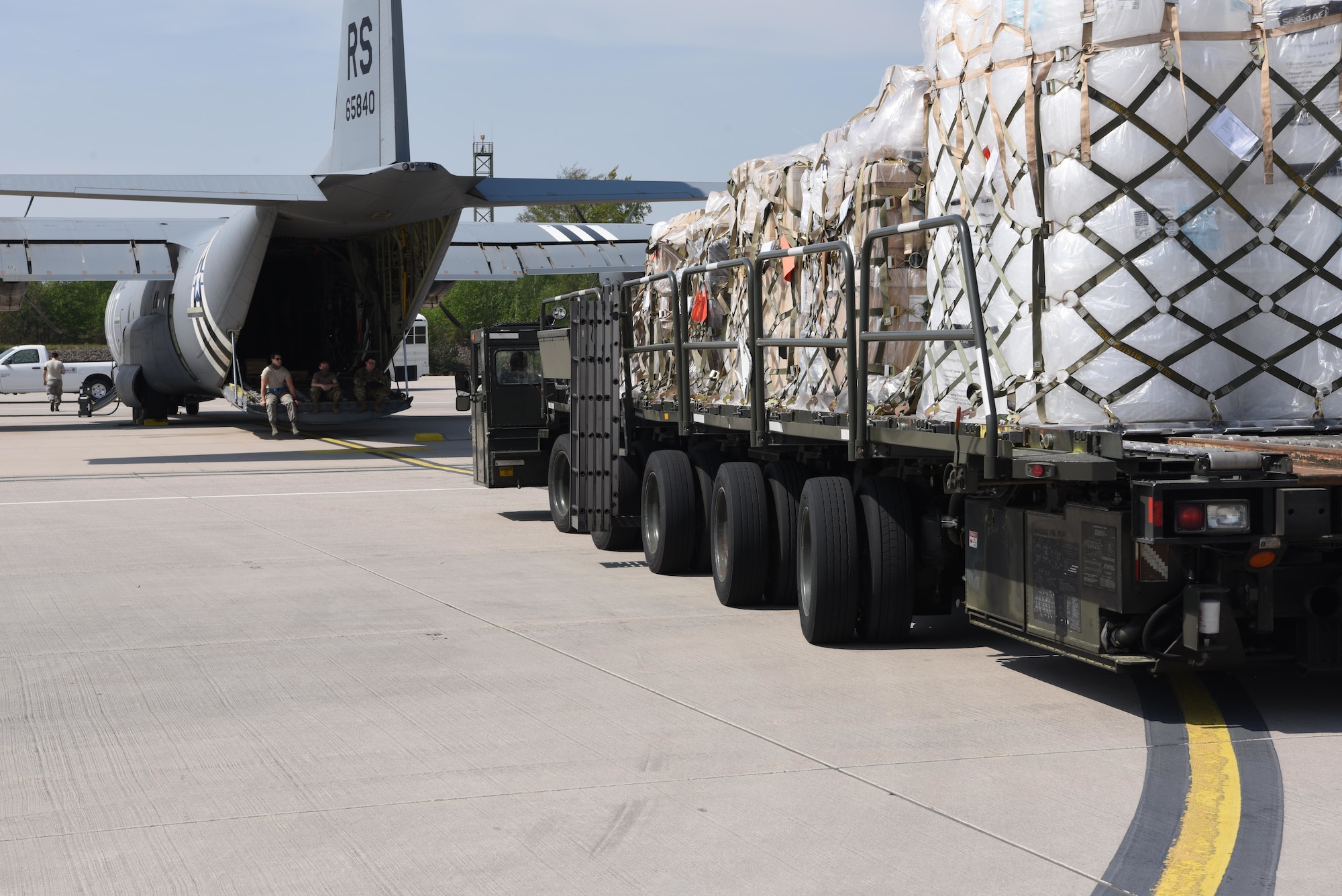 U.S. Airmen assigned to the 721st Aerial Port Squadron prepare to load a C-130J Super Hercules aircraft.