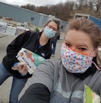 Lisa Potito, wellness team coordinator, right, and Mary Keeler, sexual assault response coordinator, left, The 104th Fighter Wing Wellness Team, help distribute food at a nonprofit farmers market that is free for the military, April 4, 2020.