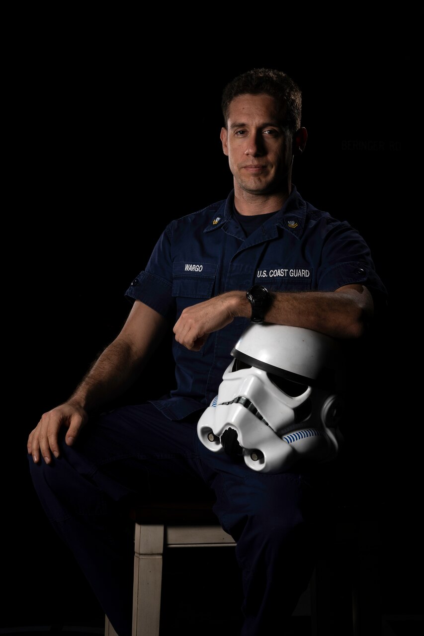 A member of the Coast Guard poses with a Storm Trooper helmet.