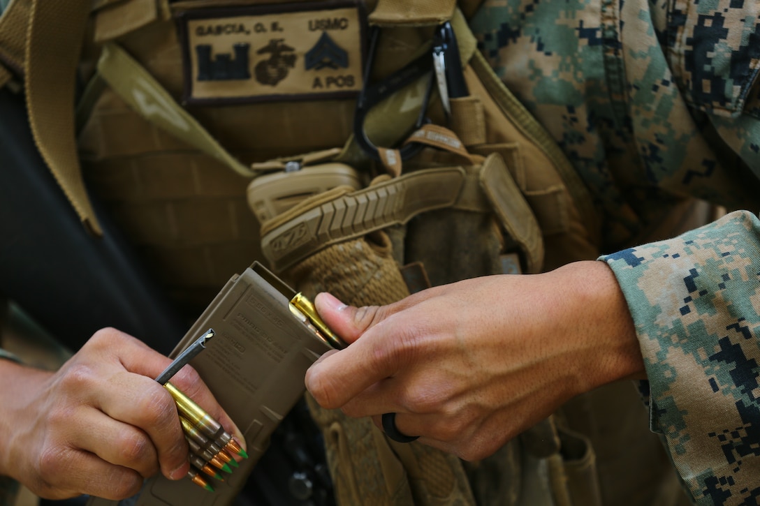 A U.S. Marine loads his magazine before shooting table 5 on Camp Hansen, Okinawa, Japan, April 27.