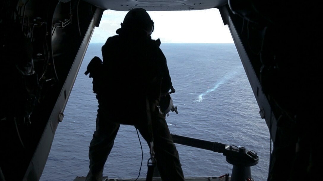 A U.S. Marine provides suppressive fire with the 240 machine gun from the MV-22 Osprey during the GAU-17 minigun weapon test off the shore of Oahu, Hawaii, April 23.