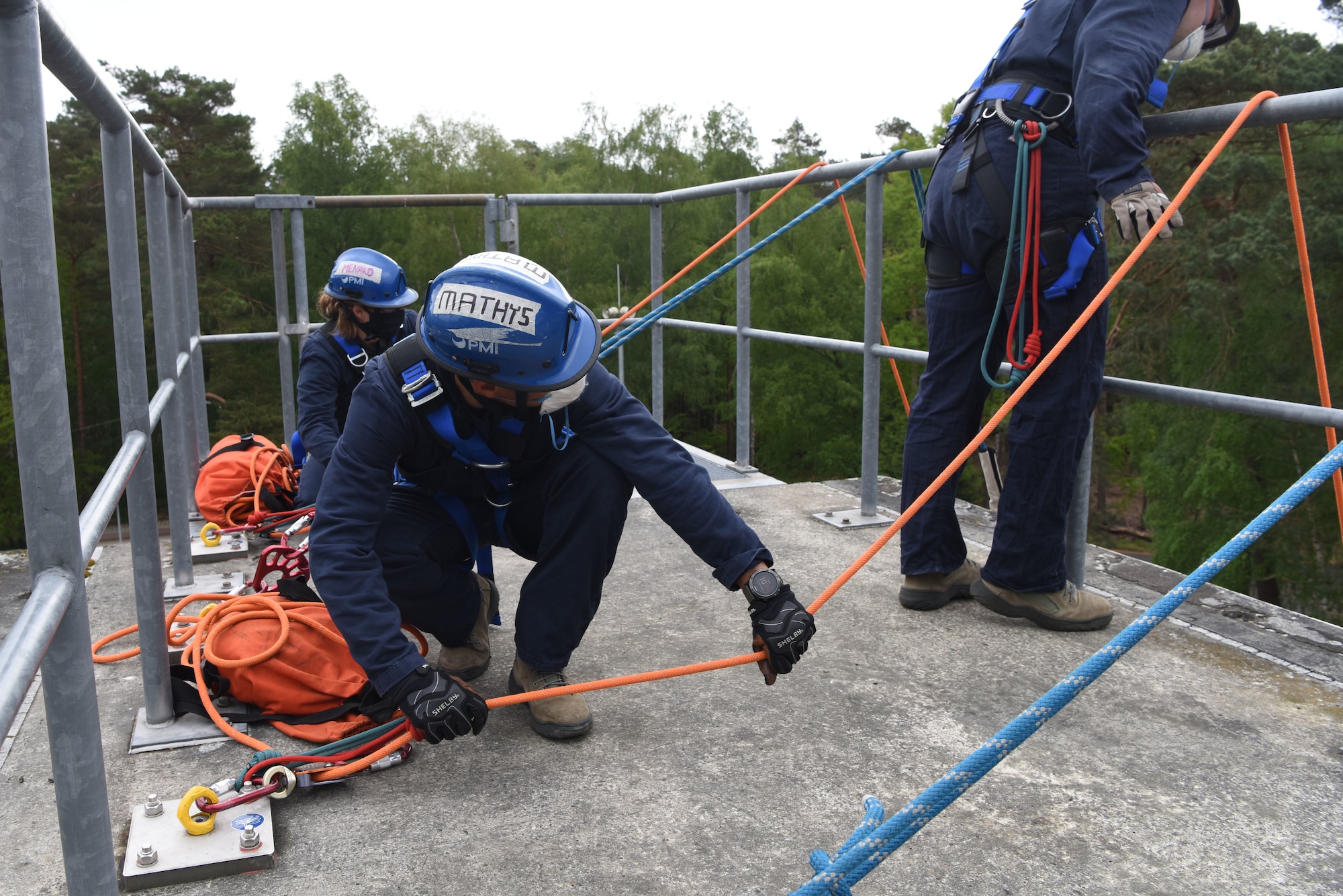 U.S. Air Force Airmen assigned to 86th Civil Engineer Squadron fire department control and monitor safety lines of Airmen rappelling a structure during a rescue certification course.