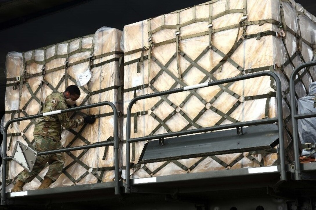 An airmen pushes pallets off a C-5 Super Galaxy.