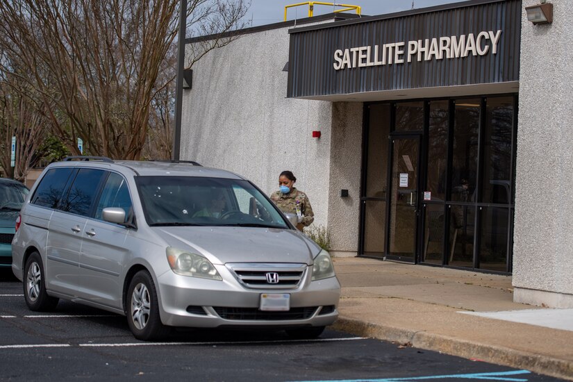 A U.S. Air Force Airman interacts with a patient at the Satellite Pharmacy at Joint Base Langley-Eustis, Virginia, March 16, 2020. The pharmacy has runners that meet the cars in the drive-thru, get the patient information, bring it inside to a pharmacy technician who then pulls up the medications for the runners to take back out to the patient’s car. (U.S. Air Force photo by Senior Airman Anthony Nin-Leclerec) (Image has been altered with a blur to hide license plate information)