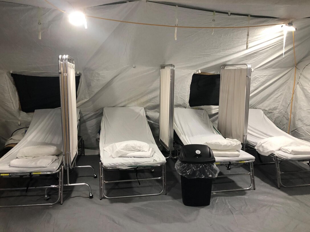 Hospital beds in a military tent.