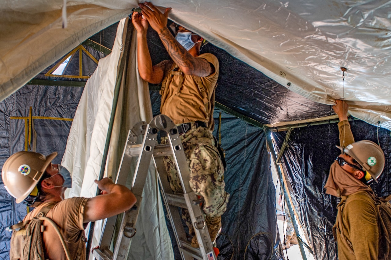 Sailors assembling a tent.