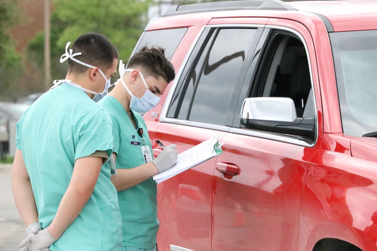 Airmen conducting drive-thru COVID-19 screenings.