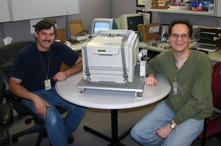 NSWC PHD engineers Mark Monaco (left) and Thomas Emmerich in 2004 with a workstation printer prototype they designed for the Tactical Tomahawk Weapon Control System (TTWCS), which influenced the program office to make their team the overall hardware design agent for TTWCS.