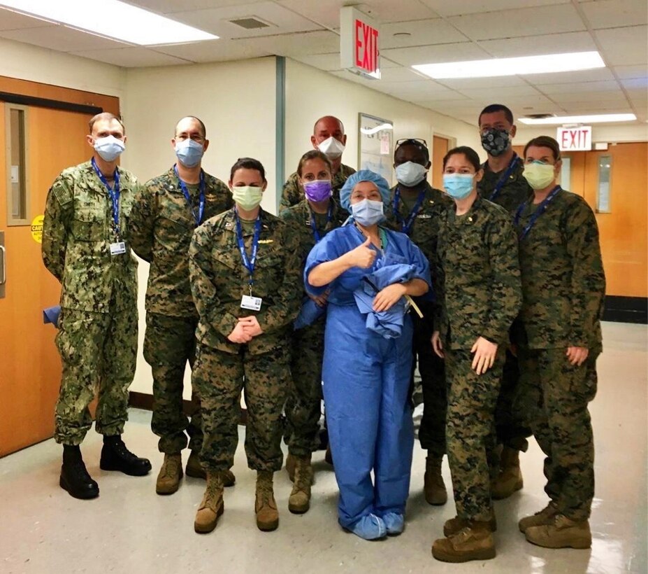 ELMHURST, Ill. – U.S. Navy Sailors with 4th Medical Battalion, Marine Corps Forces Reserve, and an Intensive Care Unit medical provider pose for a photo at Elmhurst Medical Center in Elmhurst, Ill., on the first day of orientation, April 8, 2020. Left to right: Cmdr. Lyndell Smith, OHSU Camp Lejeune; Cmdr. Thomas Shu; Lt. Sarah Dekay; Lt. Jeanine Tripp; Capt. Jerry Dotson; Ipek Pehlivan (in scrubs), Assistant Director for Perioperative Services; Lt. Cmdr. Ikeakaghichi Akanu, battalion team leader; Lt. Cmdr. Jody McIntosh; Lt. Michael Bury; Lt. Cmdr. Sandra Wright.  The Sailors, part of the Department of Defense COVID-19 response, coordinate closely with state, local, and public health authorities to ensure the well-being of their personnel and the local population.  U.S. Northern Command, through U.S. Army North, is providing military support to the Federal Emergency Management Agency to help communities in need. (Courtesy photo)