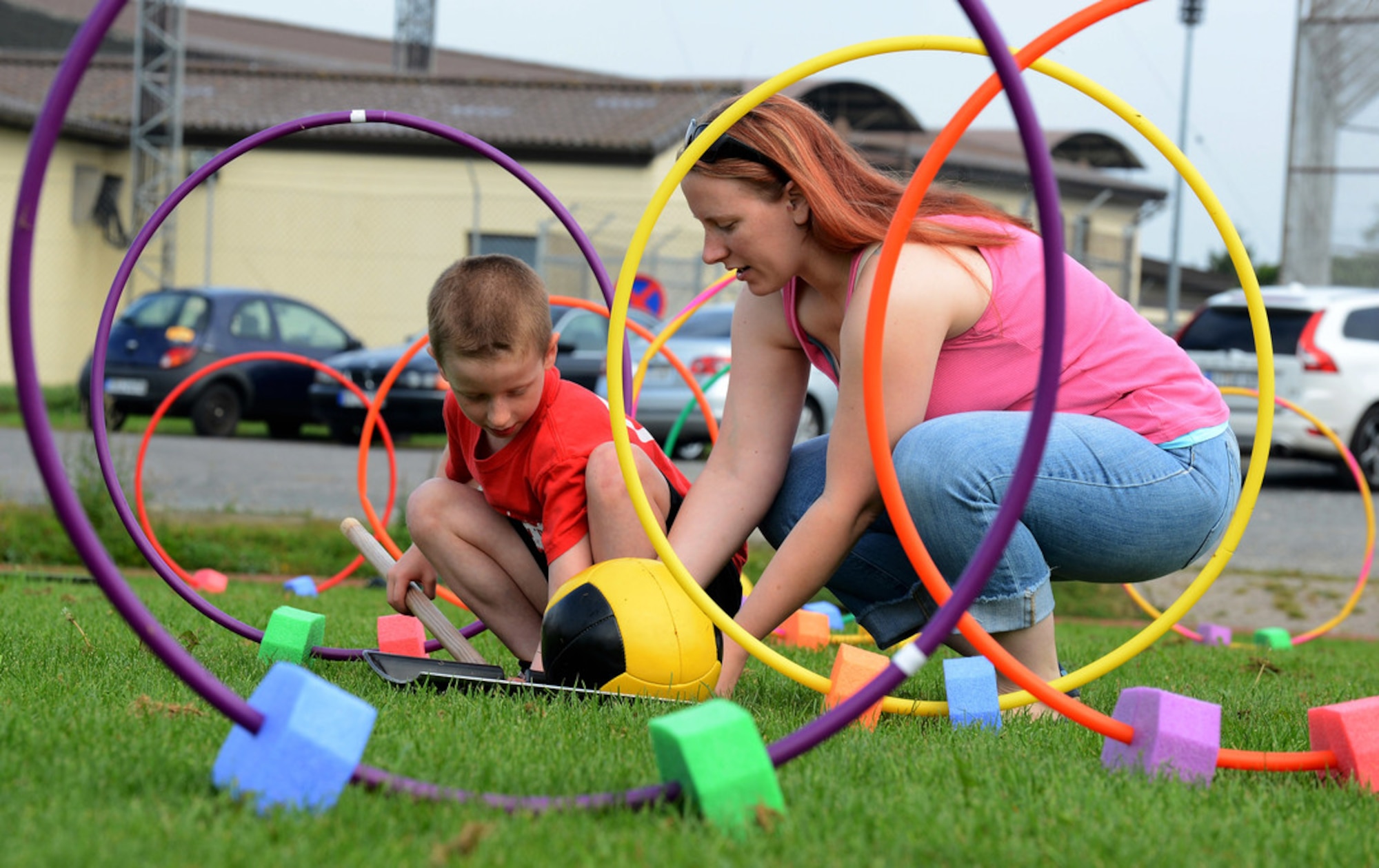 Mom and son manipulate outdoor play equipment