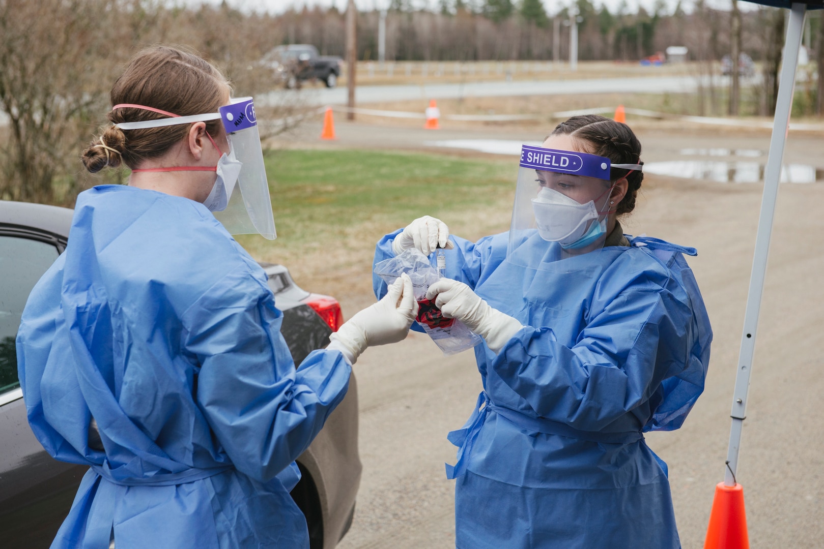 From left, Staff Sgt. Megan McMahon and Airman 1st Class Alyssa Berger of the 157th Medical Group collect a nasal sample May 1, 2020, at the Lancaster armory.