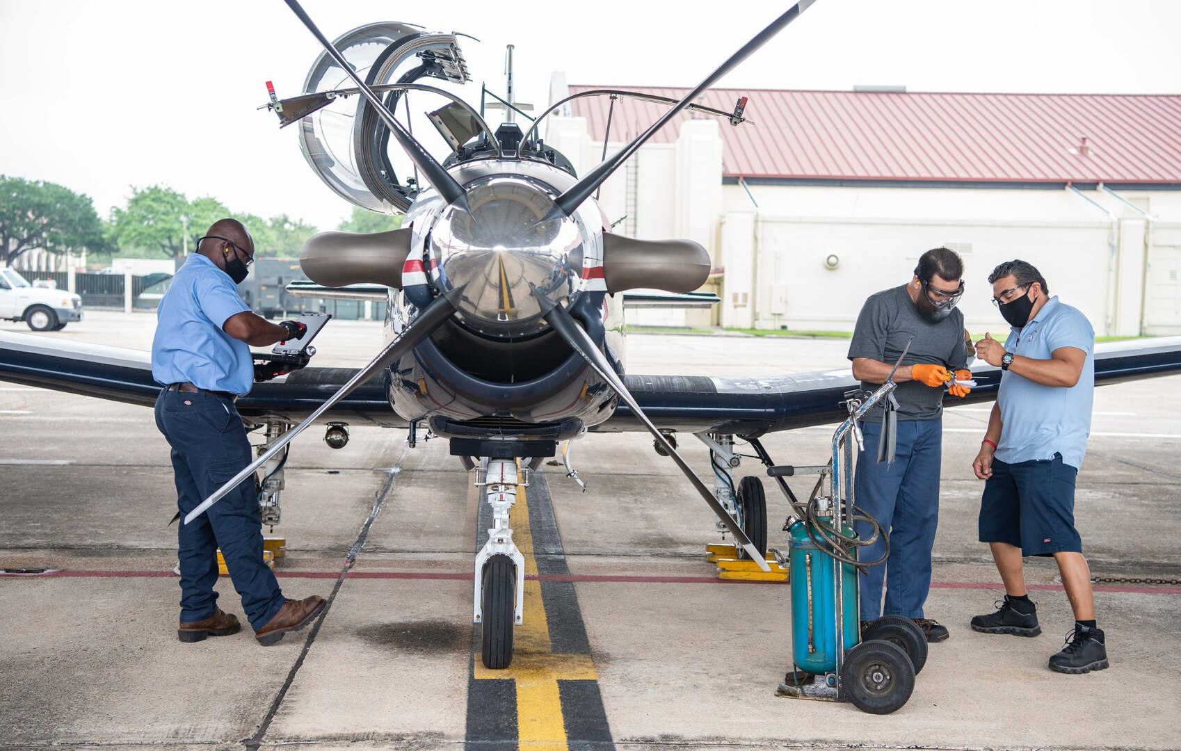 Larry Padilla, 12th Aircraft Maintenance Squadron, inspects the oil level reading of a T-6 Texan aircraft with Greg Garcia, 12th AMXS, at Joint Base San Antonio-Randolph April 7.