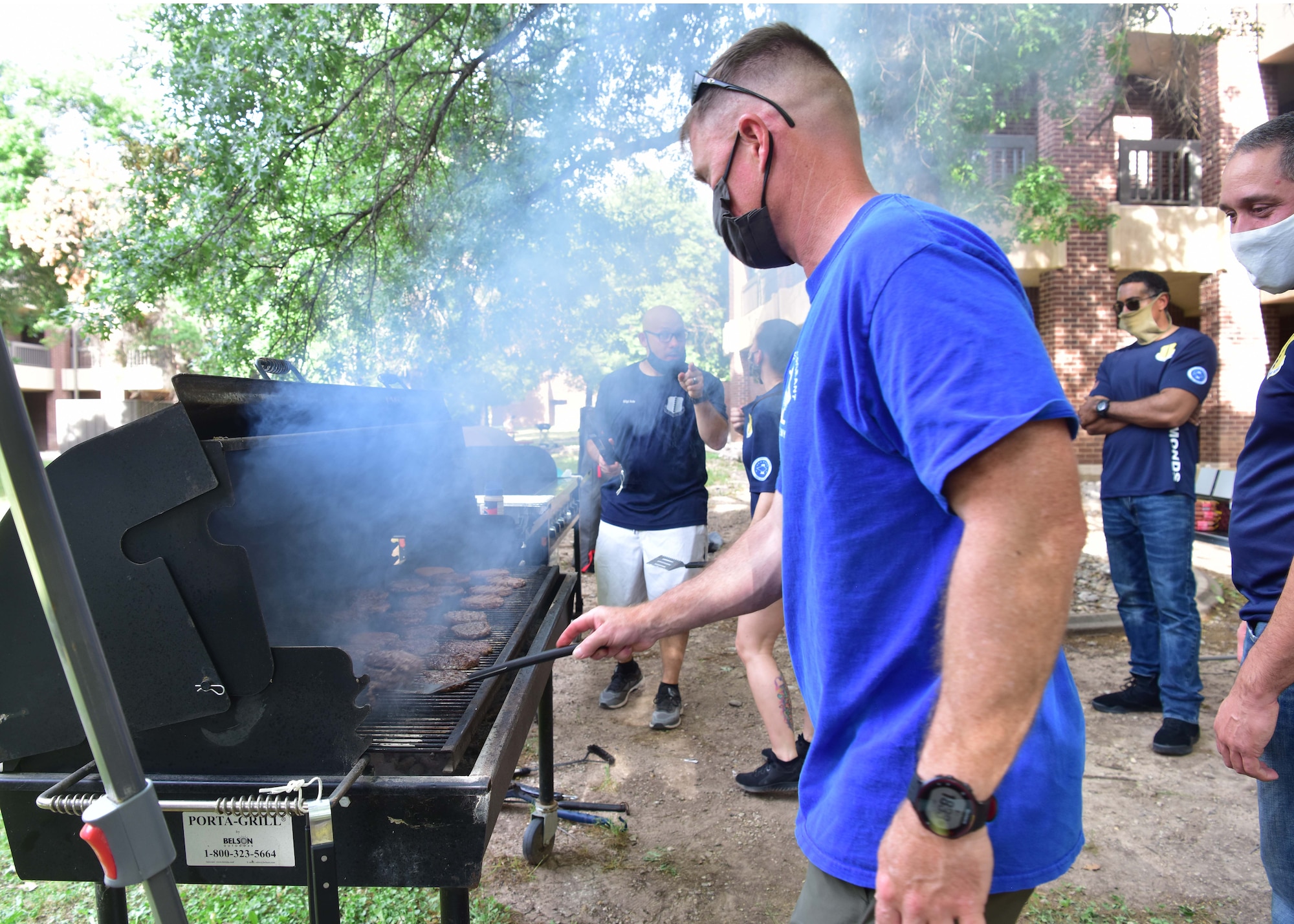 First sergeants from Goodfellow Air Force Base, Texas, cook burgers and hotdogs during the First Four morale cookout here May 1, 2020. The First Four organization funded the event with fundraising proceeds gathered through the first quarter. (U.S. Air Force photo by Staff Sgt. Chad Warren)