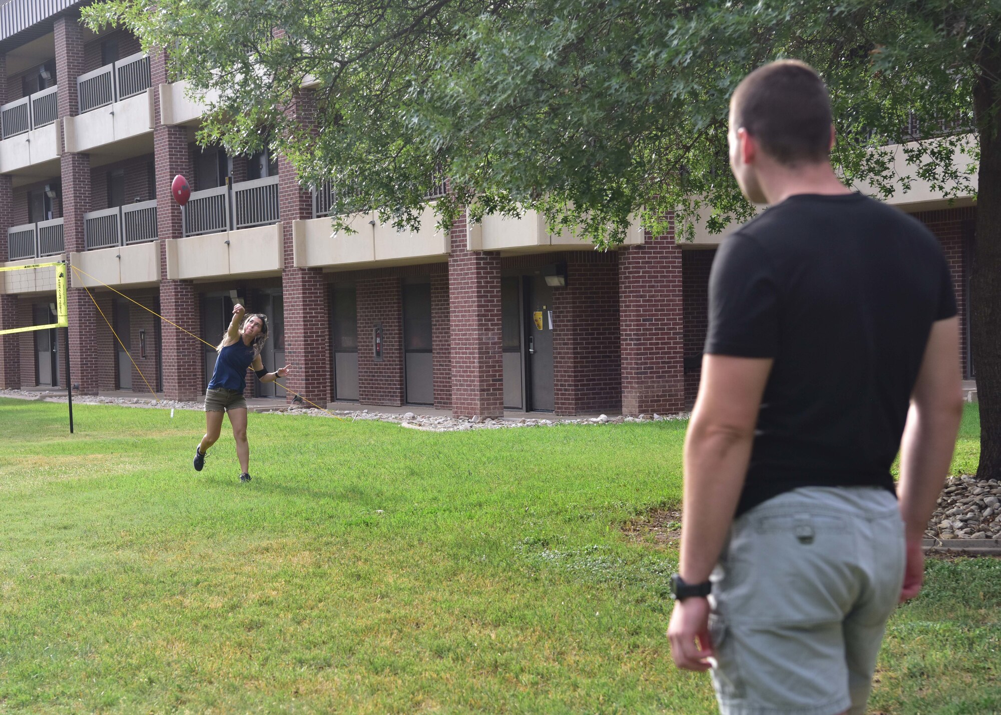 Airmen throw a football during the First Four morale cookout on Goodfellow Air Force Base, Texas, May 1, 2020. The organization hosted the event to give junior enlisted members a safe way to socialize during the COVID-19 restrictions. (U.S. Air Force photo by Staff Sgt. Chad Warren)