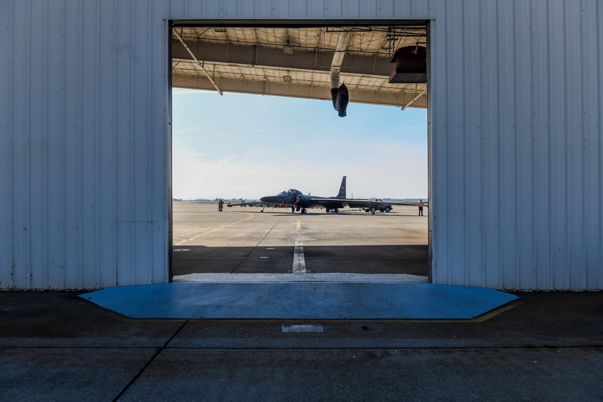 9th Aircraft Maintenance Squadron (AMXS) dedicated crew chief and members tow a U-2 Dragon Lady into a hangar