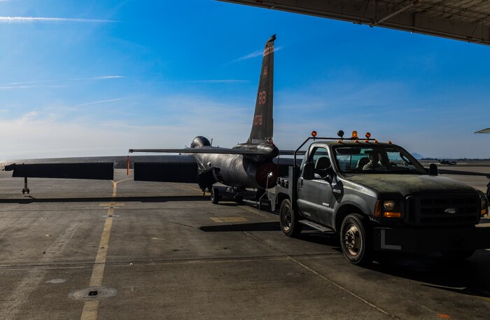 9th Aircraft Maintenance Squadron (AMXS) dedicated crew chief and members tow a U-2 Dragon Lady into a hangar