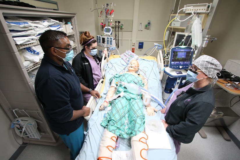 Nurses training on a medical dummy.