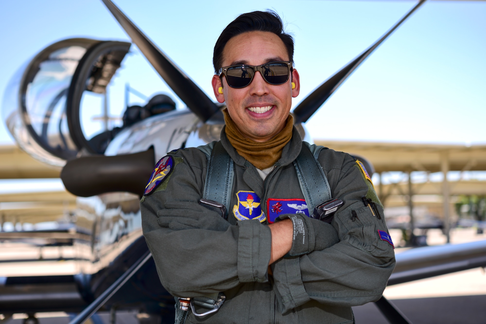 Capt. Joshua White, 434th Flying Training Squadron X flight commander and instructor pilot, stands in front of a T-6 Texan II, April 23, 2020 at Laughlin Air Force Base, Texas, wearing his mask around his neck. White finds being an instructor pilot during the COVID-19 pandemic proves a challenge while following safety guidances. “As an instructor pilot, it’s our job to be in close proximity to many people--students, other instructors, and maintainers,” White said. “It’s been difficult to find the balance between social distancing and being an effective instructor.” (U.S. Air Force photo by Senior Airman Anne McCready)