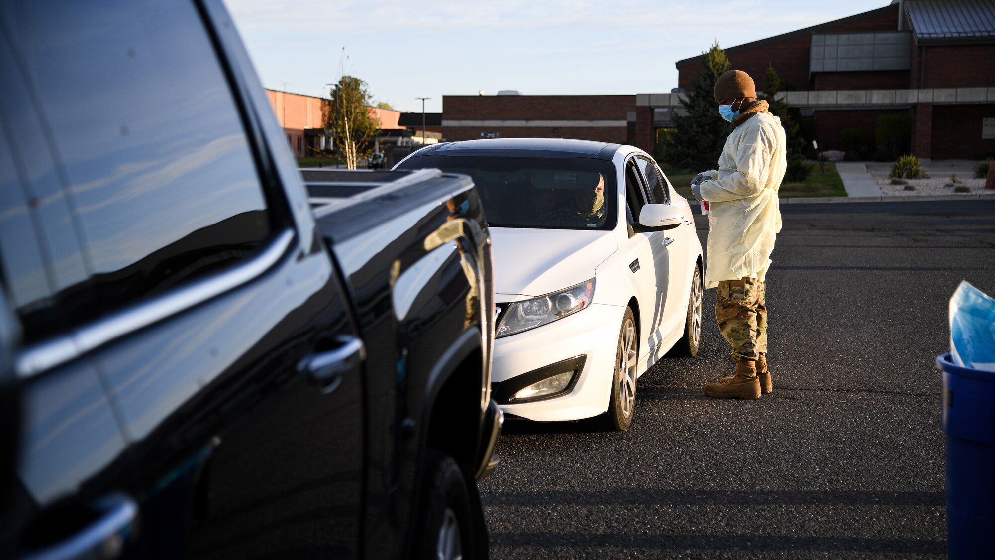 Airman 1st Class Nicolas Porter, 75th Medical Group, talks with a visitor during a drive-thru COVID-19 screening.