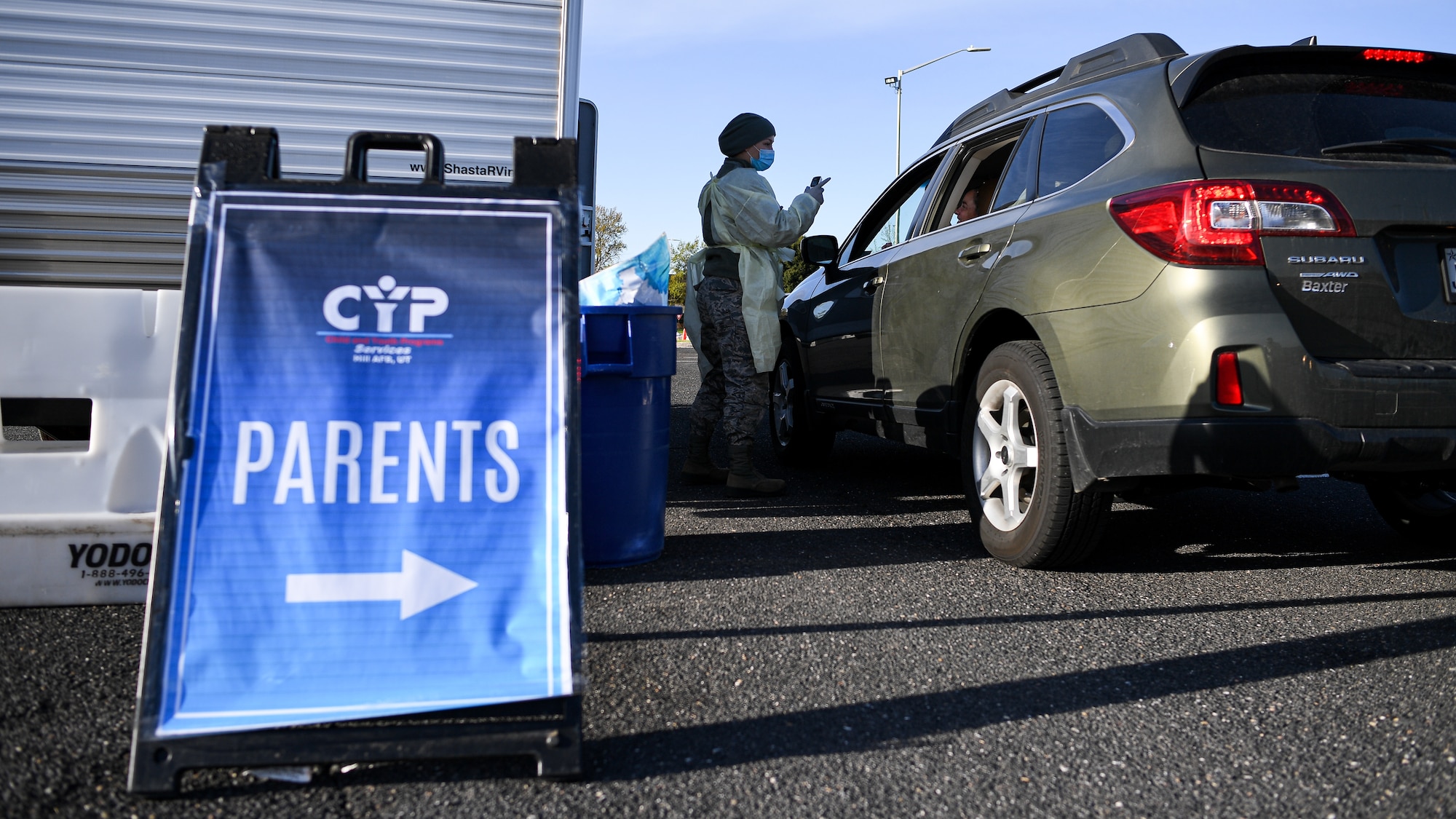 Senior Airman Amber Sansevieri, 75th Medical Group, interacts with a visitor during a drive-thru COVID-19 screening.