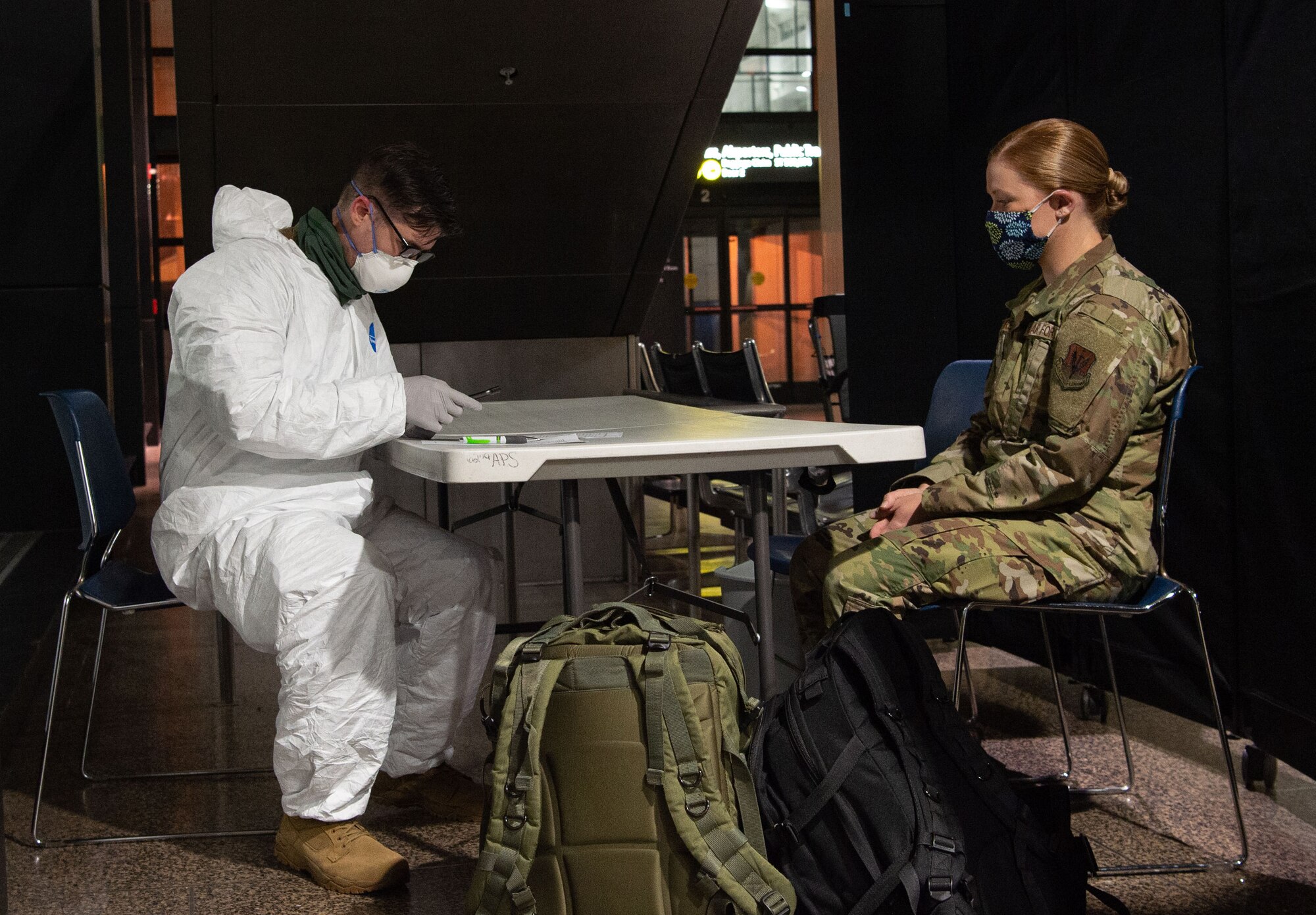Staff Sgt. Benjamin Guris, 62nd Medical Squadron aerospace medical technician, left, conducts a secondary medical screening on a passenger traveling to Asia at the Seattle-Tacoma International Airport in Seattle, Wash., April 30, 2020. Secondary screenings are conducted for passengers who may be ill or work in a medical facility to ensure they have not contracted COVID-19. (U.S. Air Force photo by Senior Airman Tryphena Mayhugh)