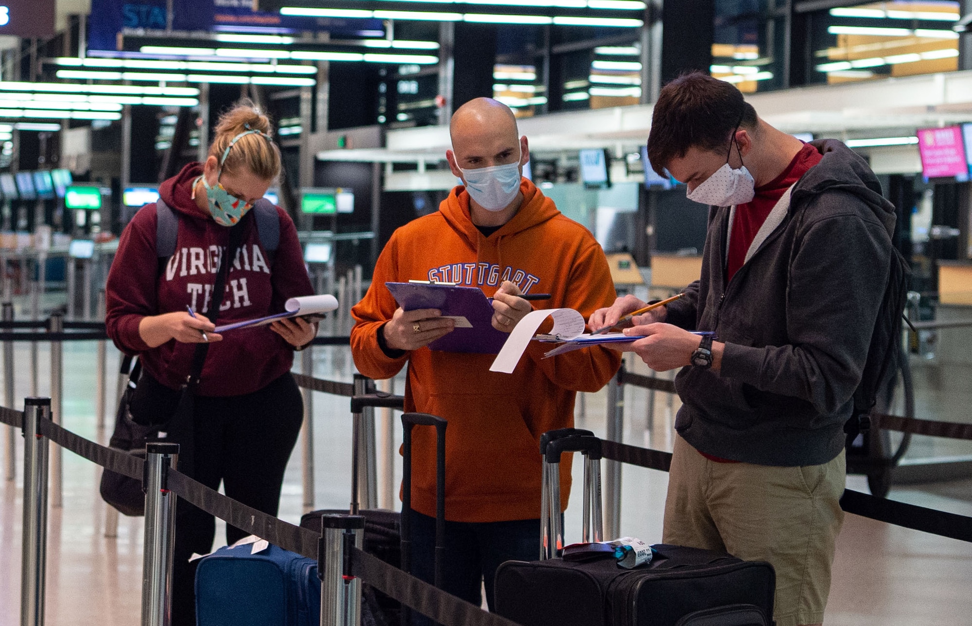 Passengers traveling through the Air Mobility Command terminal fill out medical questionnaires at the Seattle-Tacoma International Airport in Seattle, Wash., April 30, 2020. The questionnaires are part of a new screening process implemented by the 62nd Aerial Port Squadron to prevent the spread of COVID-19. (U.S. Air Force photo by Senior Airman Tryphena Mayhugh)