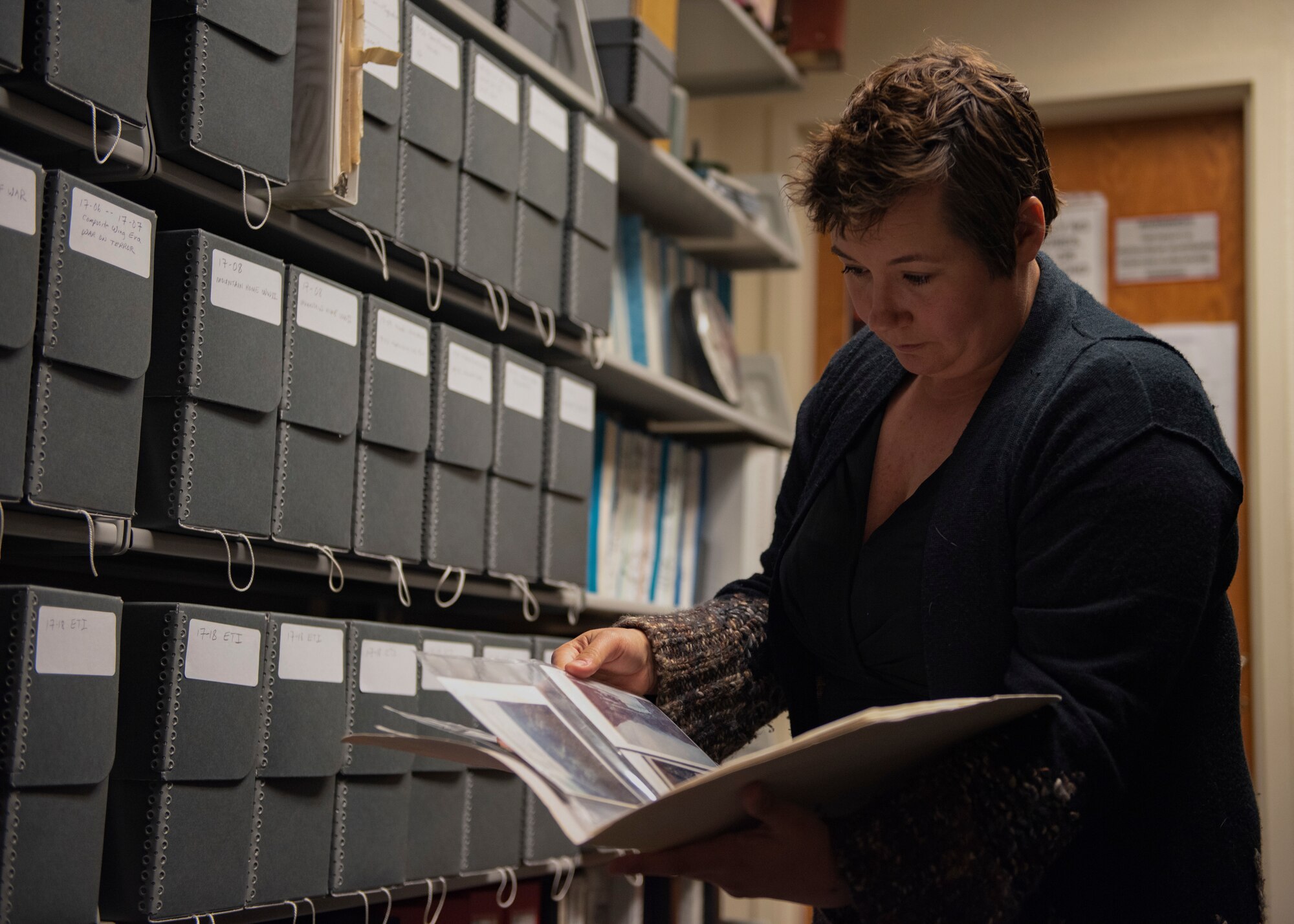 Chrissie Parker, 366th Fighter Wing historian, looks through historical images, May 4, 2020, at Mountain Home Air Force Base, Idaho. Parker has been the historian at MHAFB since 2018. (U.S. Air Force photo by Airman Natalie Rubenak)
