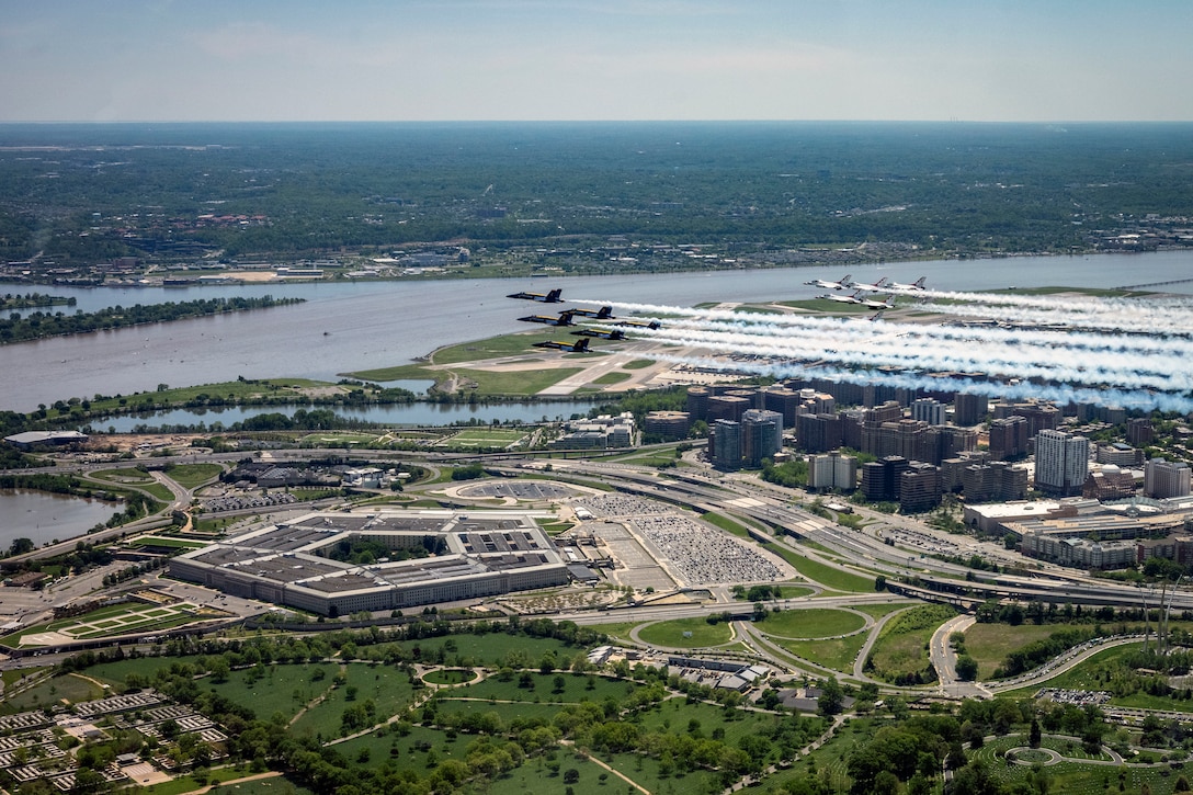 Two groups of military aircraft fly over the Pentagon.