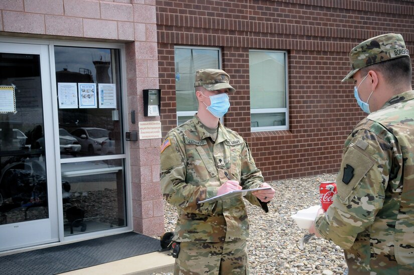 Spc. Padric Marianos, a construction engineer with the PAARNG Training Center, screens a Soldier outside the 28th ECAB Armory. The 28th ECAB is scheduled to deploy soon and must gather for training. Soldiers like Marianos screen 28th ECAB Soldiers everyday before they enter the building or start their training for the day to prevent the spread of COVID-19 in the formation.