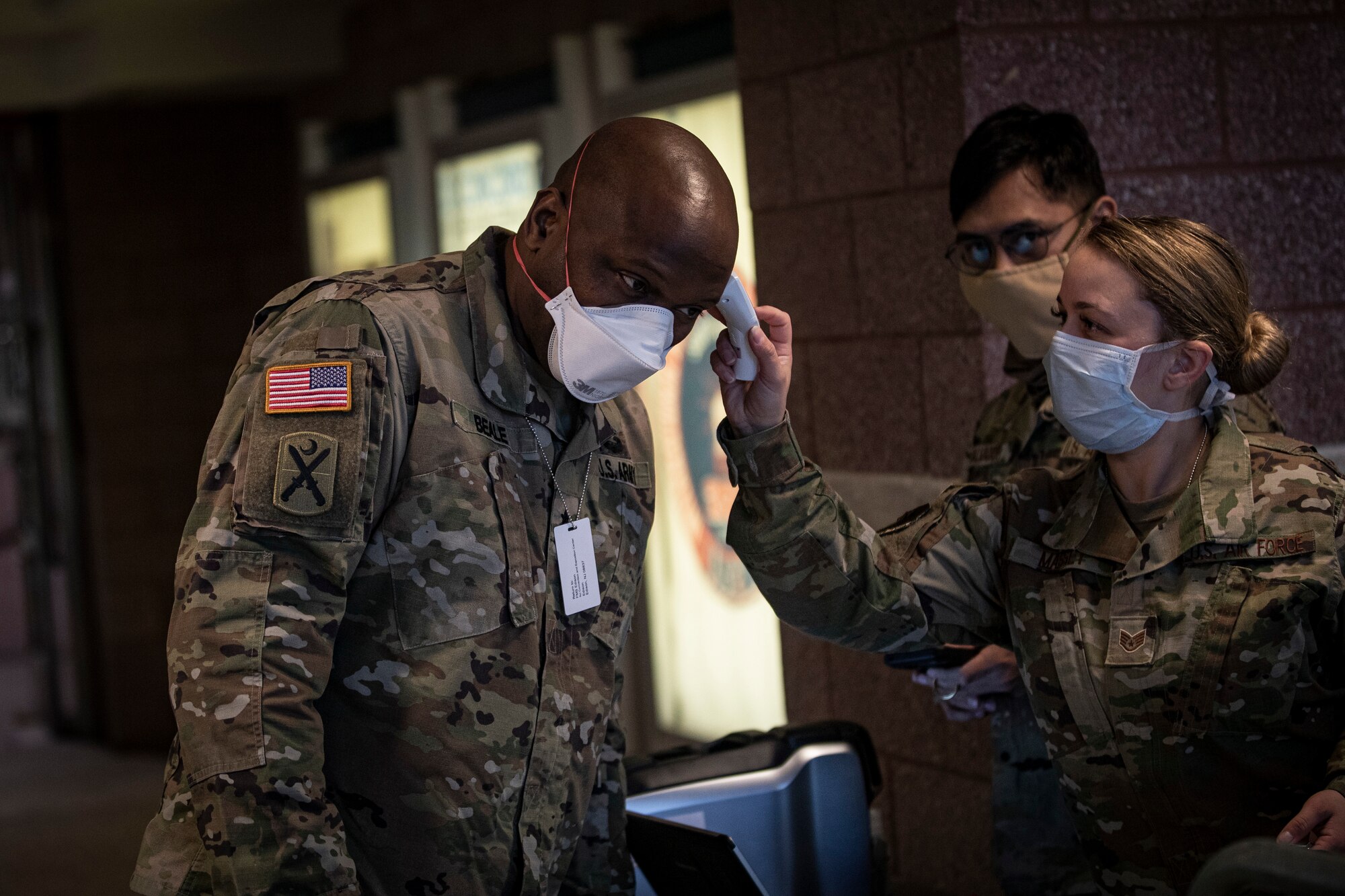 U.S. Army Brig. Gen. Jemal J. Beale, the Adjutant General of New Jersey, has his temperature taken by Air Force Staff Sgt. Samantha Massey at the entry control point for the Federal Medical Station inside the Atlantic City Convention Center, Atlantic City, N.J., April 21, 2020. The station was developed in conjunction with numerous organizations, including the FEMA, the U.S. Army Corps of Engineers, the Department of Health, the Office of Emergency Management, and the New Jersey National Guard. It is the third Federal Medical Station in the state, designed to ease the burden on local hospitals responding to the COVID-19 outbreak. (U.S. Air National Guard photo by Master Sgt. Matt Hecht)