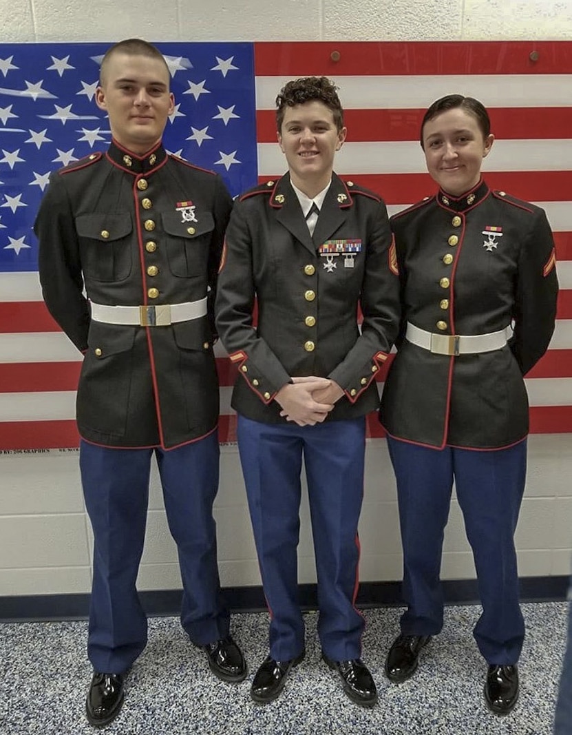 Staff Sgt. Mallory Kirk poses for a photo during a high school visit with two recently graduated Marines. Kirk is a recruiter with Recruiting Substation Mobile, AL.