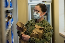 Hospitalman Seaman Apprentice Gianna Tamburro, assigned to the Naval Medical Readiness Training Command, organizes prescriptions alphabetically according to the names of patients at the Naval Health Clinic Charleston Pharmacy at Joint Base Charleston, S.C., April 24, 2020. The NHCC Pharmacy altered their customer service operations to have the primary way to obtain a prescription be through the drive-thru. Pharmacy personnel are protecting patients and themselves by washing their hands every 30 mins, practicing physical distancing, wearing masks and cleaning routinely.