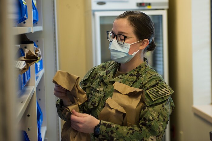 Hospitalman Seaman Apprentice Gianna Tamburro, assigned to the Naval Medical Readiness Training Command, organizes prescriptions alphabetically according to the names of patients at the Naval Health Clinic Charleston Pharmacy at Joint Base Charleston, S.C., April 24, 2020. The NHCC Pharmacy altered their customer service operations to have the primary way to obtain a prescription be through the drive-thru. Pharmacy personnel are protecting patients and themselves by washing their hands every 30 mins, practicing physical distancing, wearing masks and cleaning routinely.