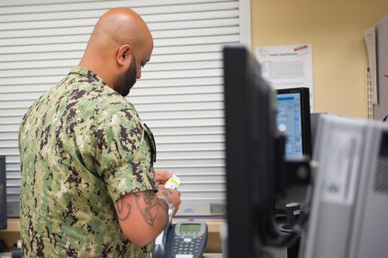 Hospital Corpsman Petty Officer Second Class Paul Veiga, assigned to Naval Medical Readiness Training Command, prepares a prescription at Naval Health Clinic Charleston Pharmacy at Joint Base Charleston, S.C., April 24, 2020. The NHCC Pharmacy altered their customer service operations to have the primary way to obtain a prescription be through the drive-thru. Pharmacy personnel are protecting patients and themselves by washing their hands every 30 mins, practicing physical distancing, wearing masks and cleaning routinely.