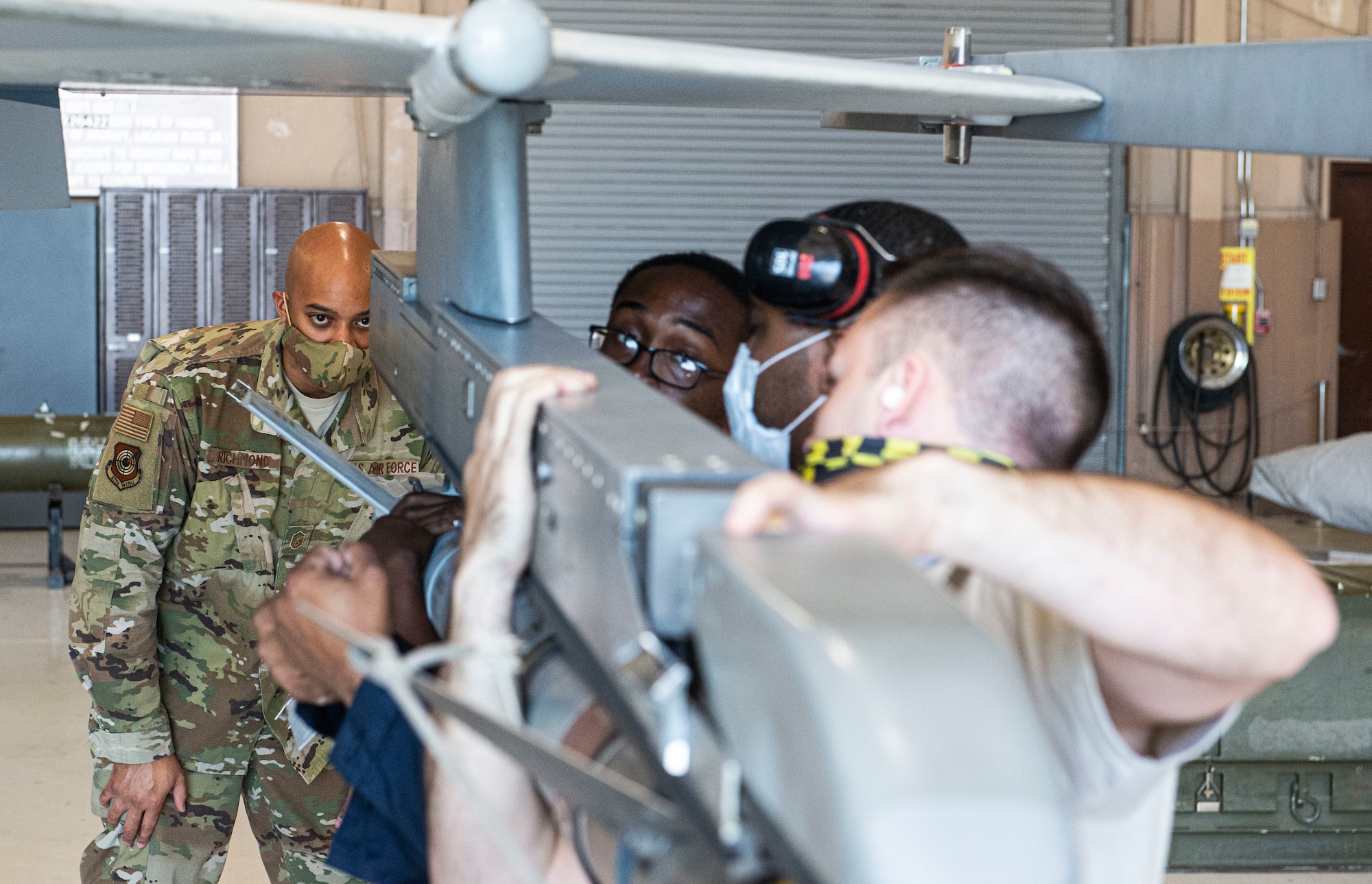 Master Sgt. LaMarr Richmond (left), 57th Maintenance Group weapons standardization crew lead, inspects a weapon load crew as they undergo certification.