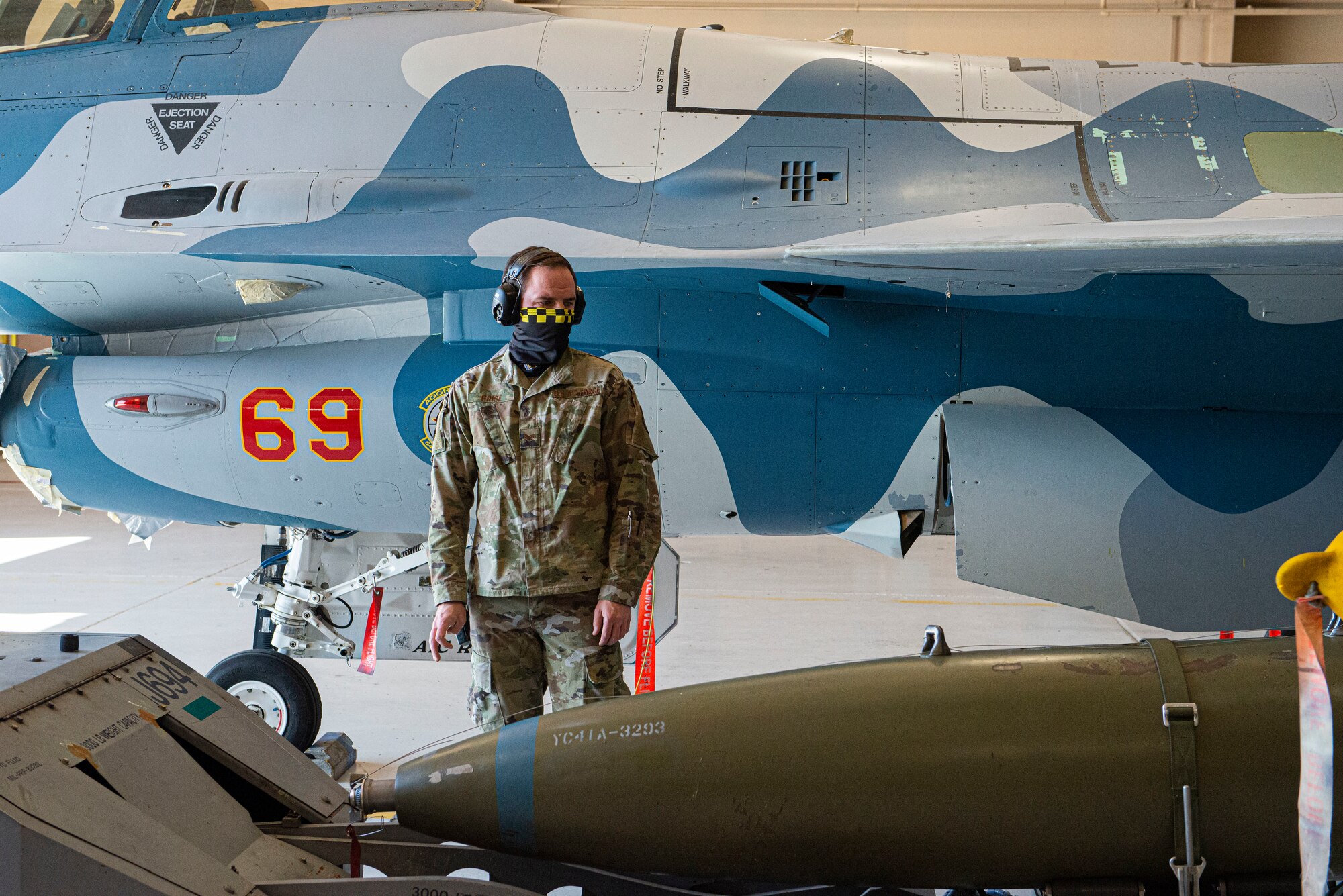 Staff Sgt. Thomas Grise, 57th Maintenance Group weapons standardization instructor, observes the progress of a weapons load crew recertification.